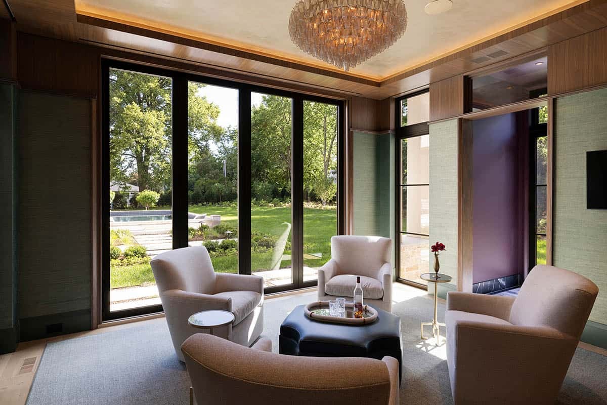 Wood-paneled sitting room with glass doors framing backyard pool
