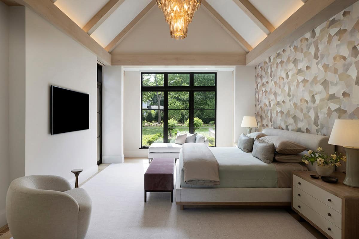 Primary bedroom with vaulted wood beams and mosaic accent wall