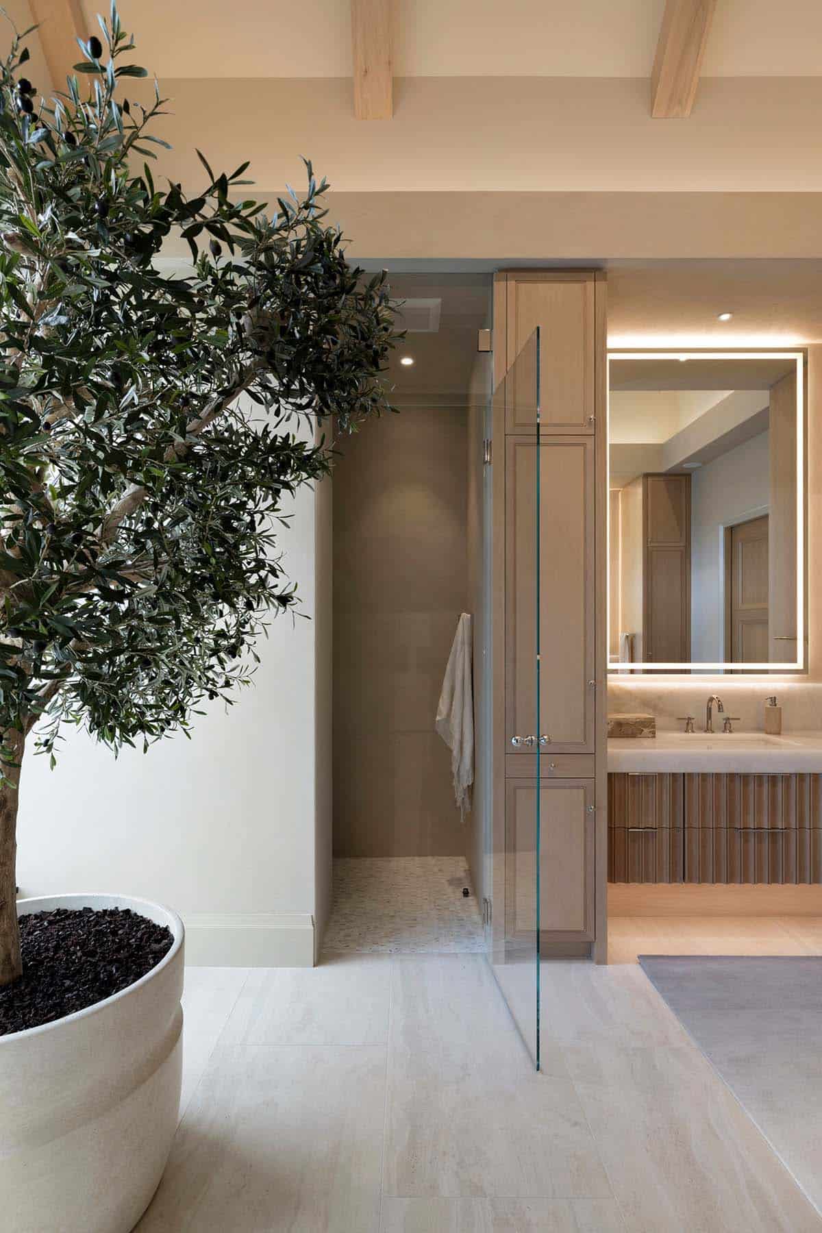 Bathroom vanity with fluted wood cabinetry and backlit mirror