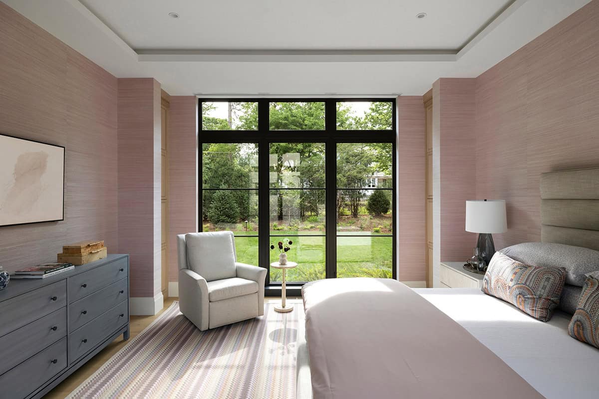 Bedroom with pink grasscloth walls and black steel doors