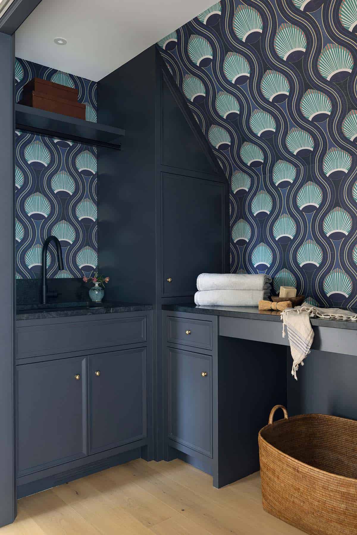 Blue laundry nook with scalloped wallpaper and woven basket