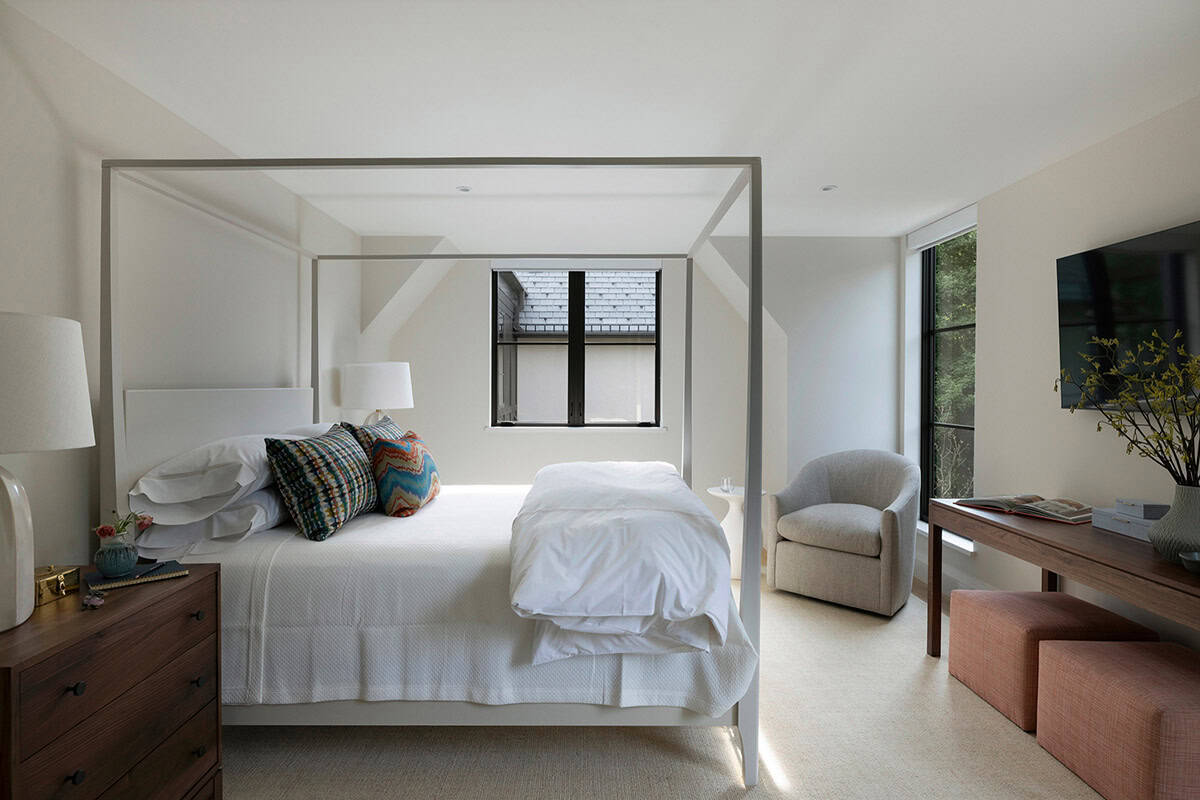Guest bedroom with canopy bed and colorful woven pillows