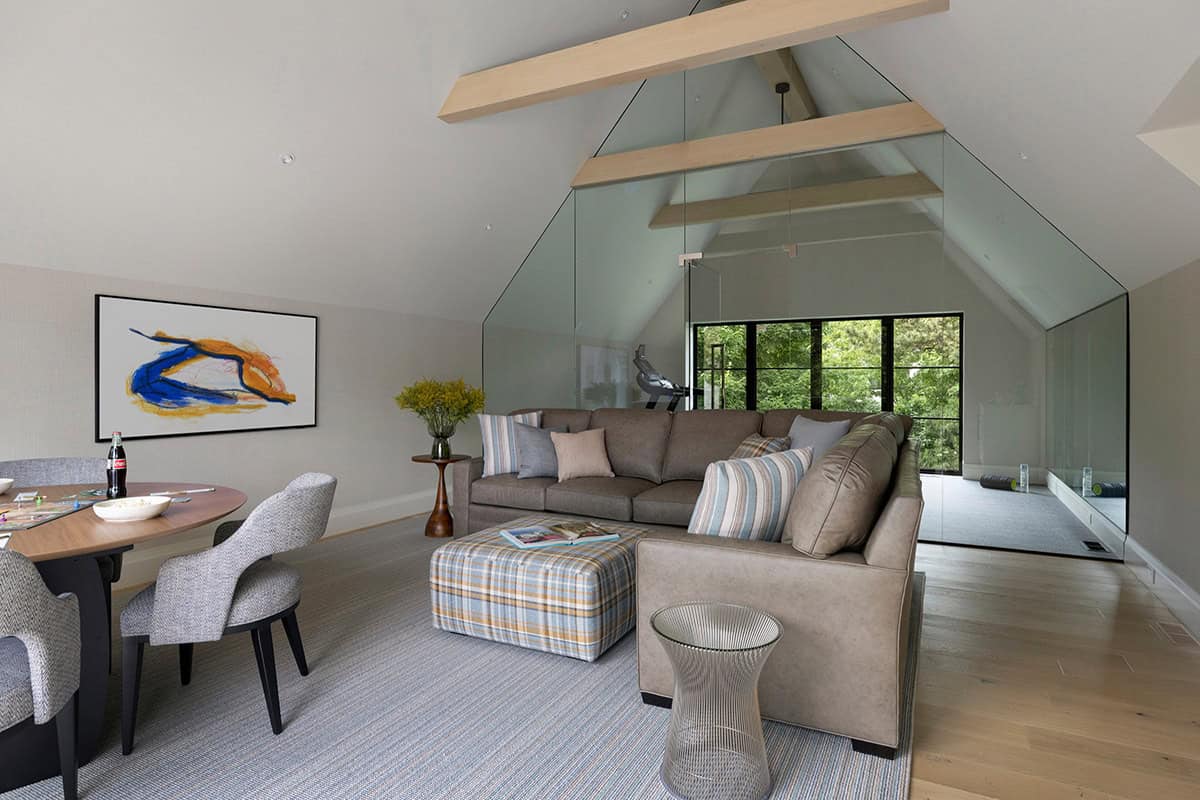 Glass-enclosed gym loft with peaked wood beam ceiling