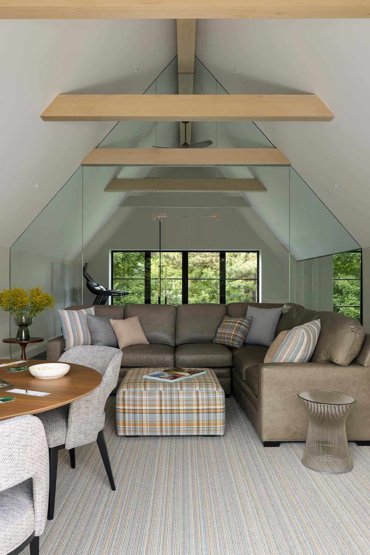 Glass gym loft with striped rug and leather sectional