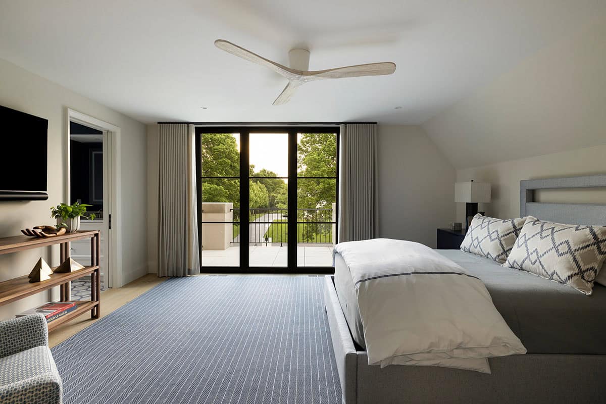 Primary bedroom with striped rug and juliet balcony doors