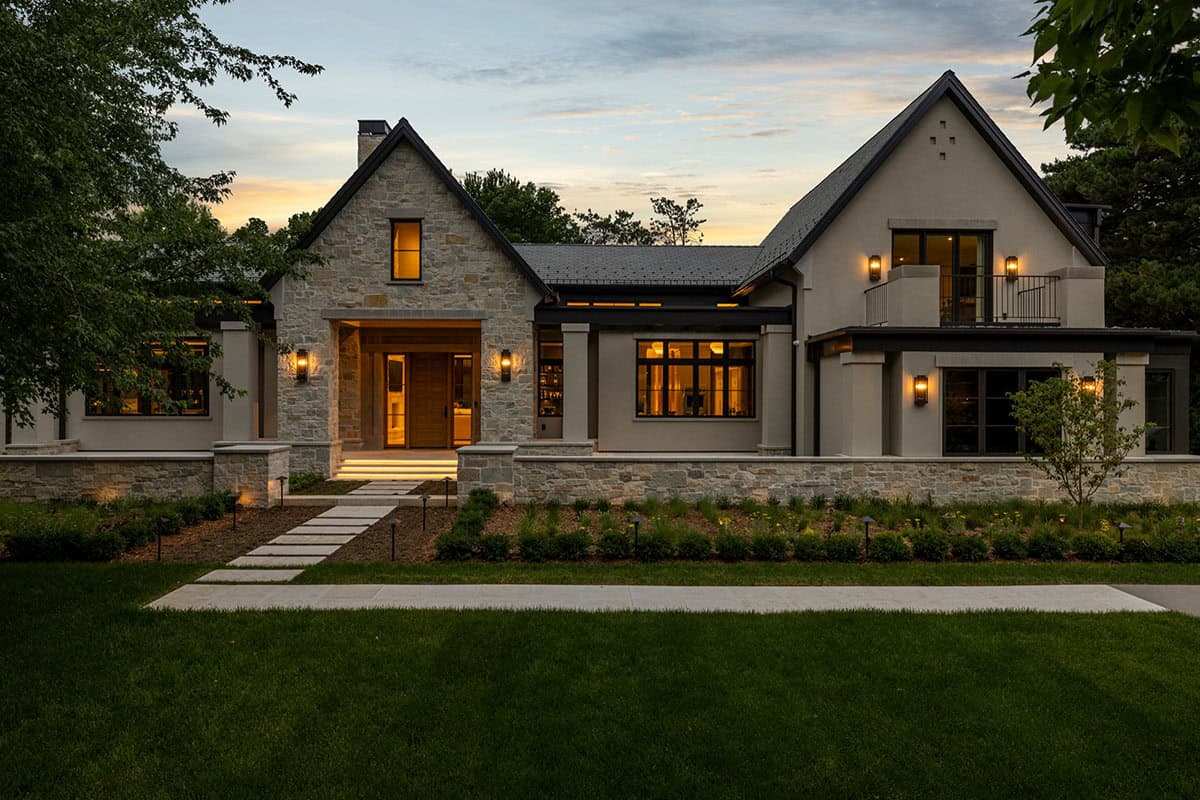 Stone and stucco facade glowing at dusk with lit windows