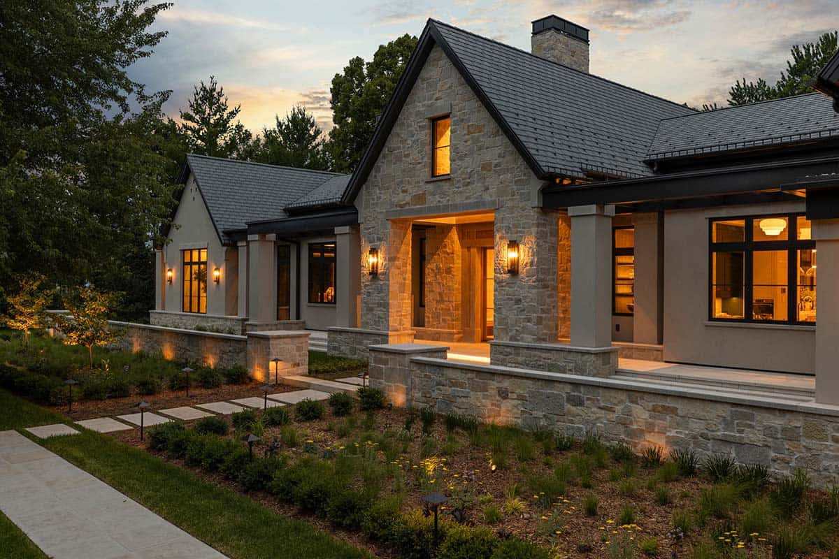 Stone gabled entry porch lit warmly at dusk