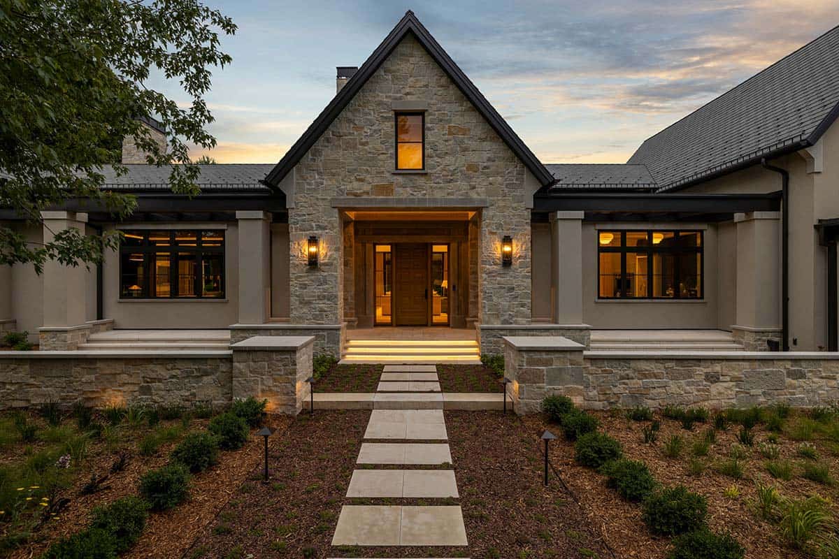 Symmetrical stone entry gable with covered walkway at twilight