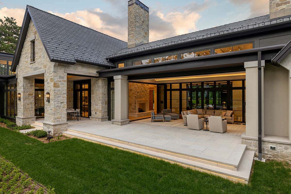 Covered stone patio framing living room with stacked stone fireplace