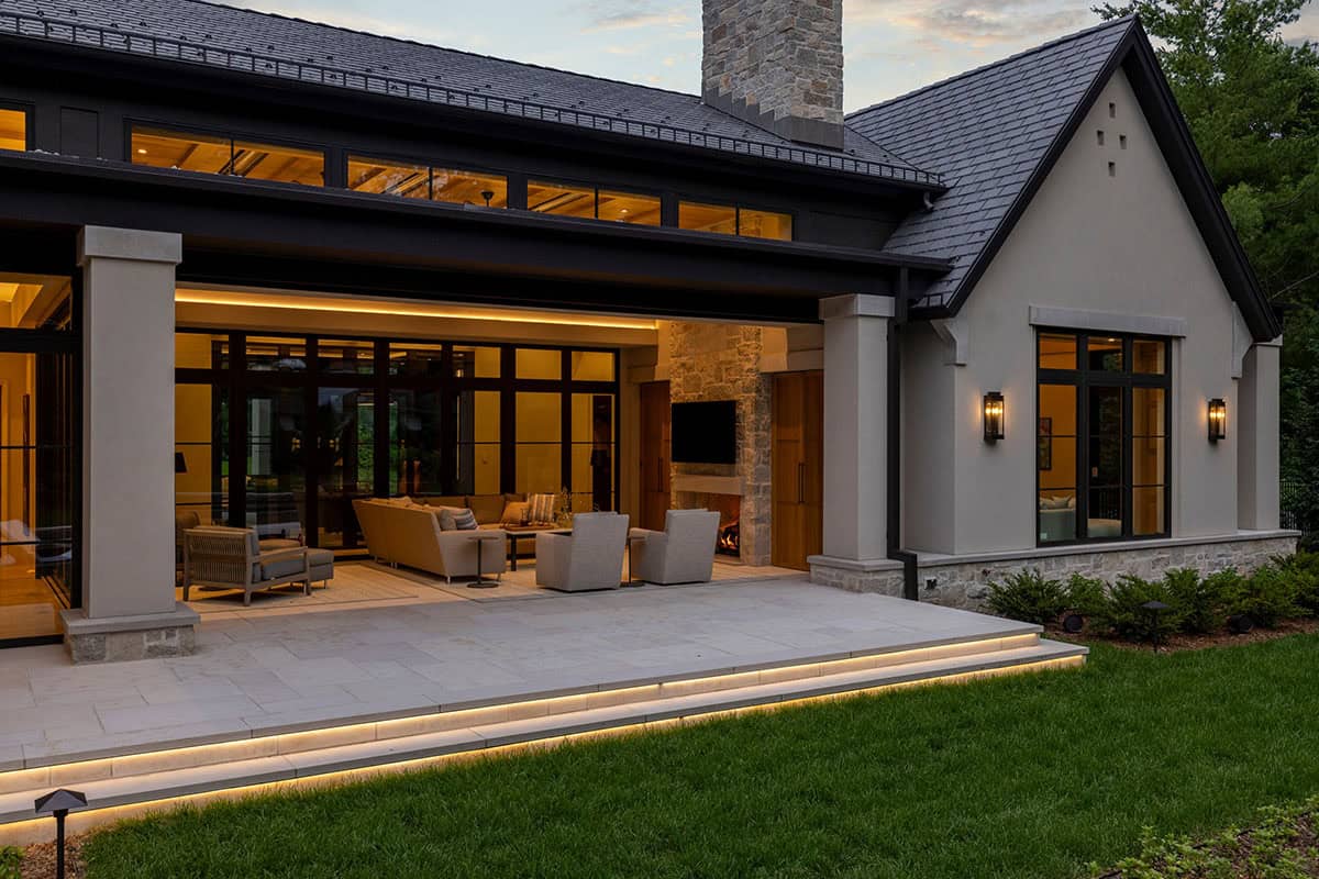 Covered patio and gabled facade glowing warmly at twilight