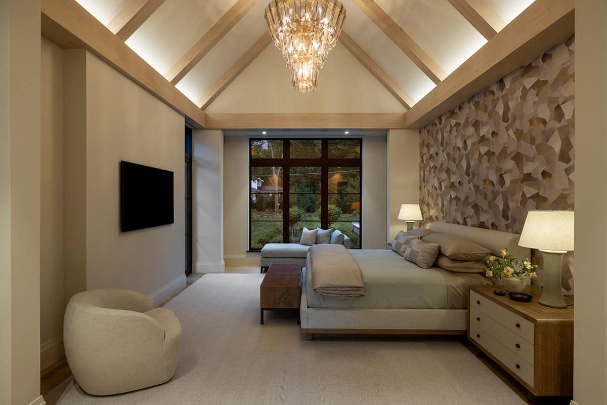 Primary bedroom with vaulted beams and geometric accent wall