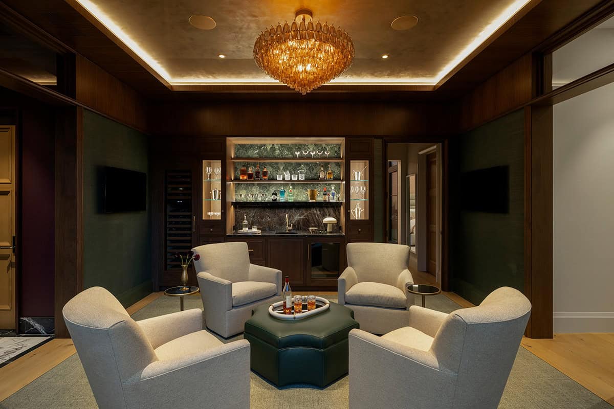 Dark paneled lounge with amber chandelier and built-in bar