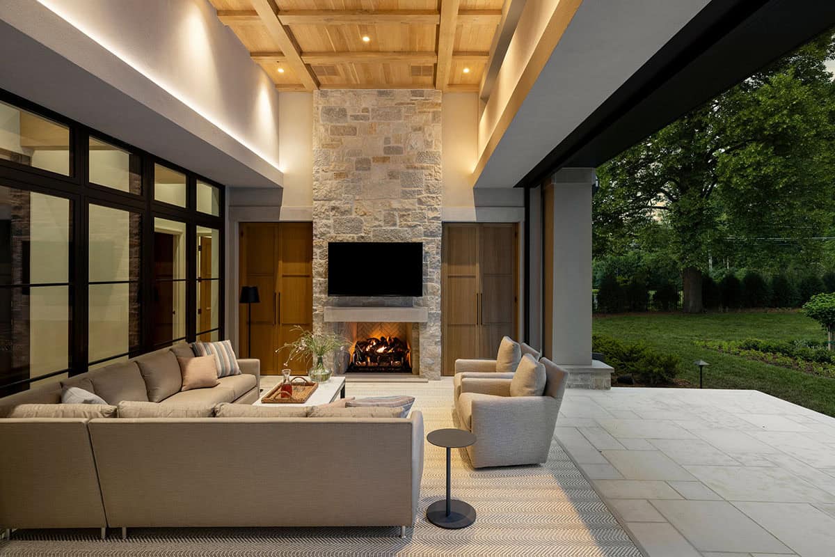 Outdoor living area with herringbone fireplace and coffered ceiling