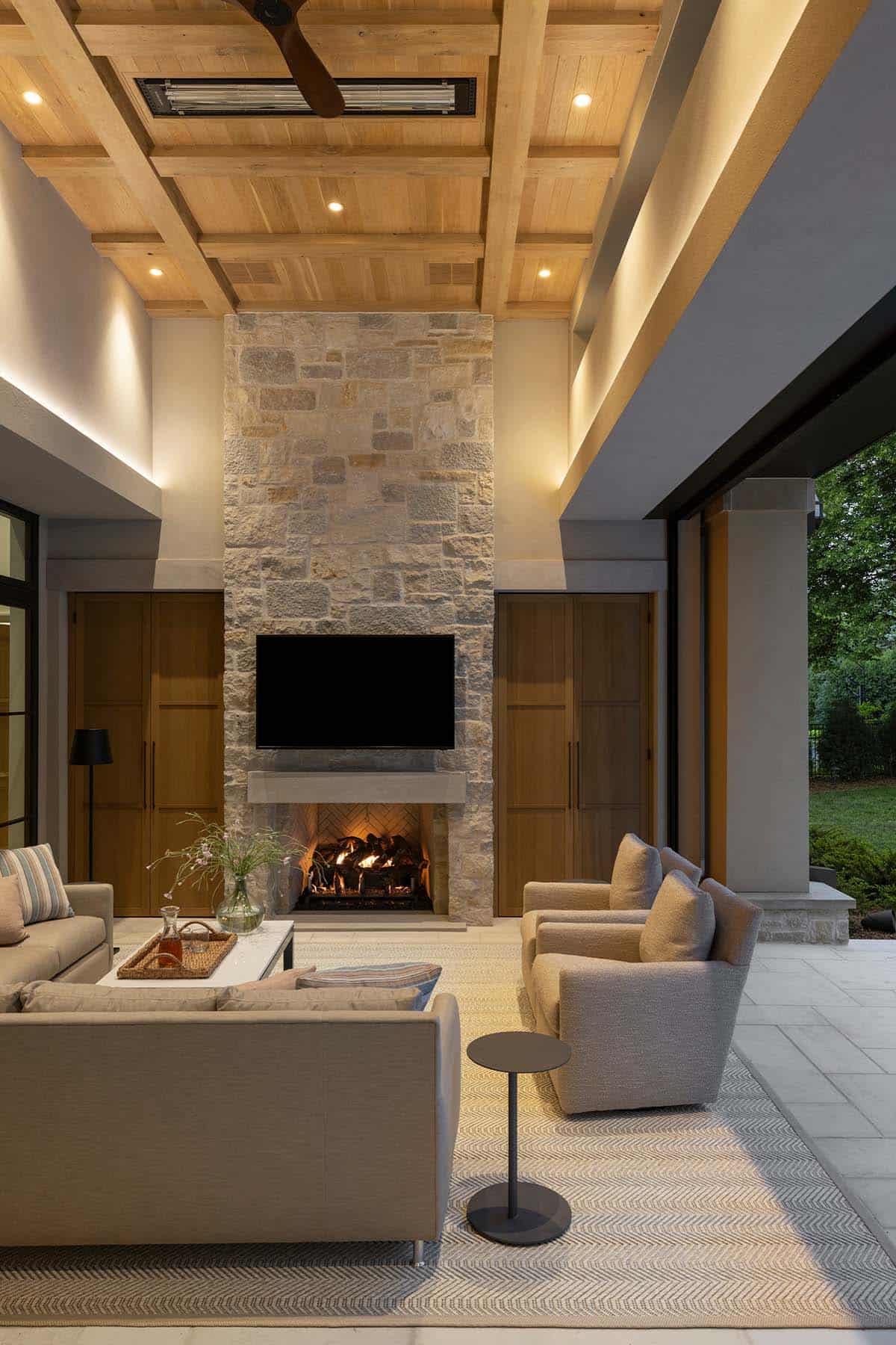 Outdoor fireplace nook with radiant heaters and ceiling fan