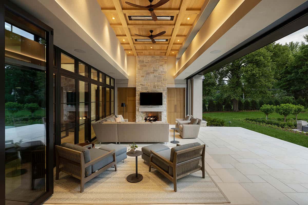Covered patio seating with stone fireplace and coffered wood ceiling