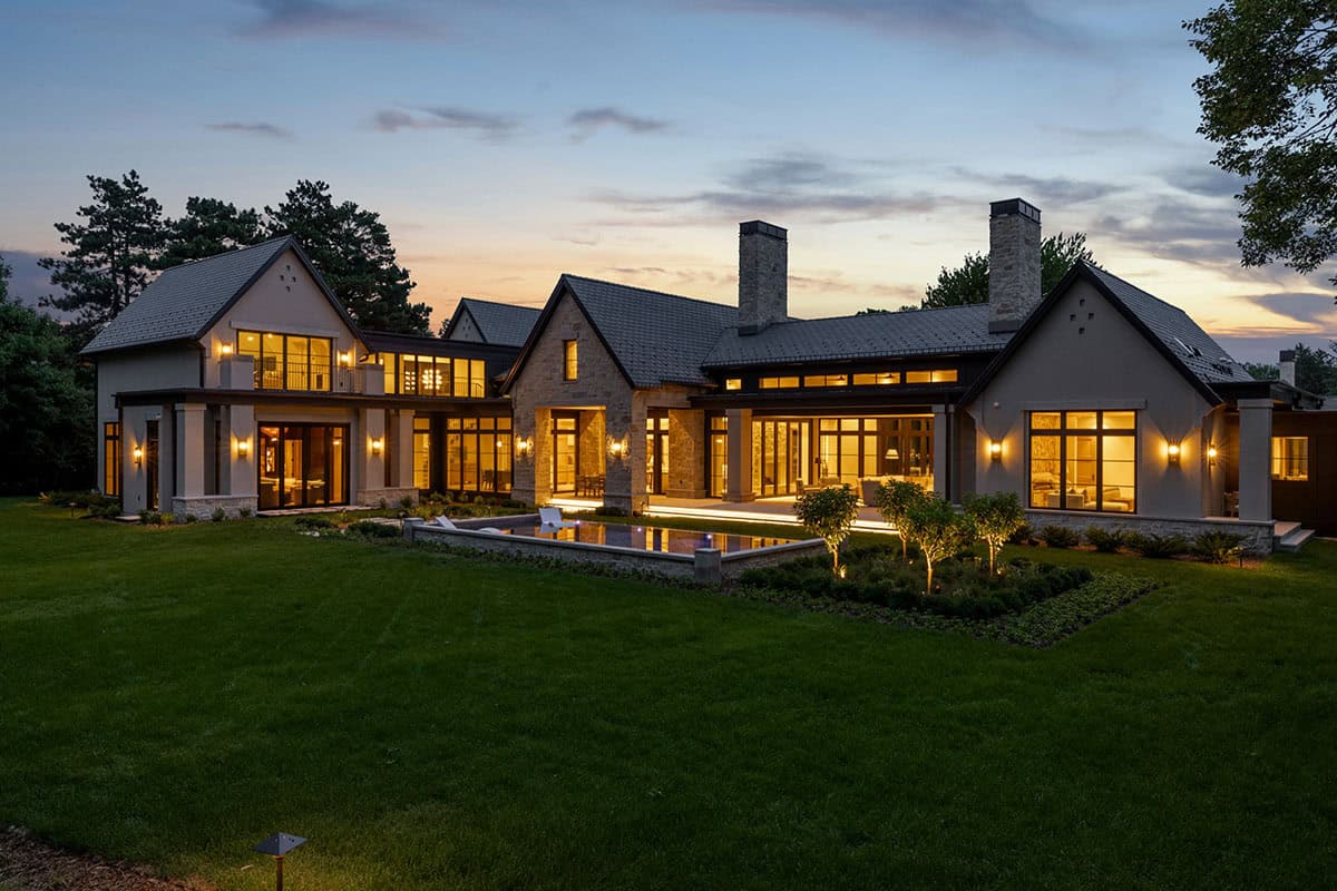 Rear facade with twin chimneys and pool glowing at sunset