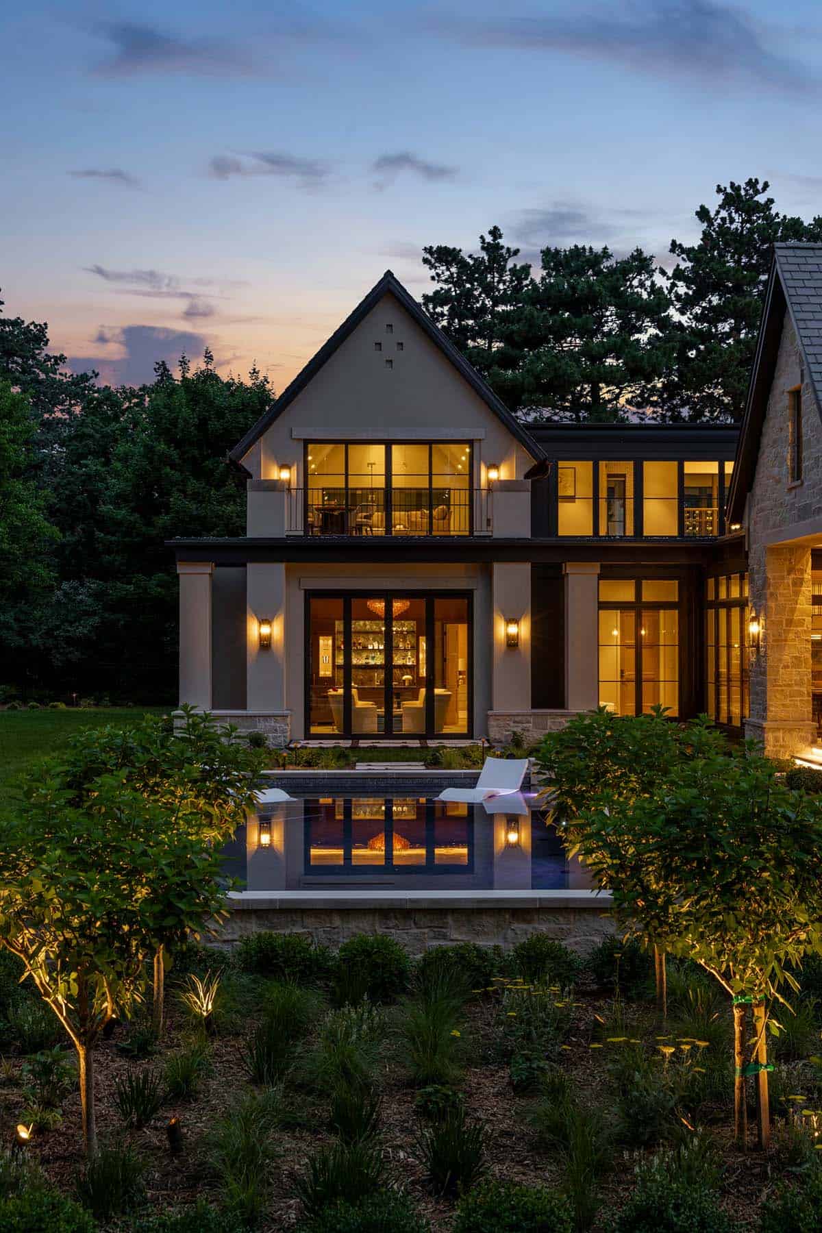 Rear facade at dusk with reflecting pool and lit bar room