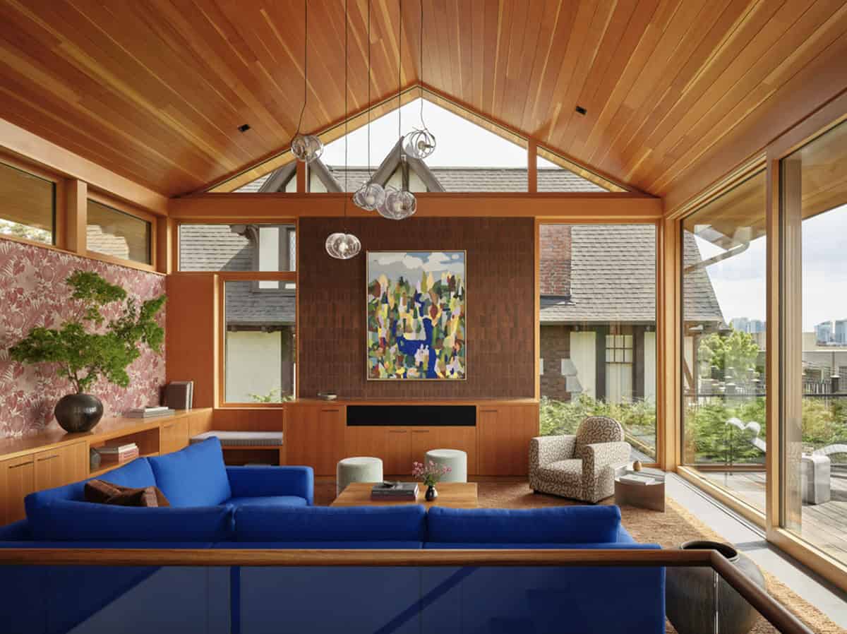 Vaulted cedar living room with floral wallpaper and blue sofa