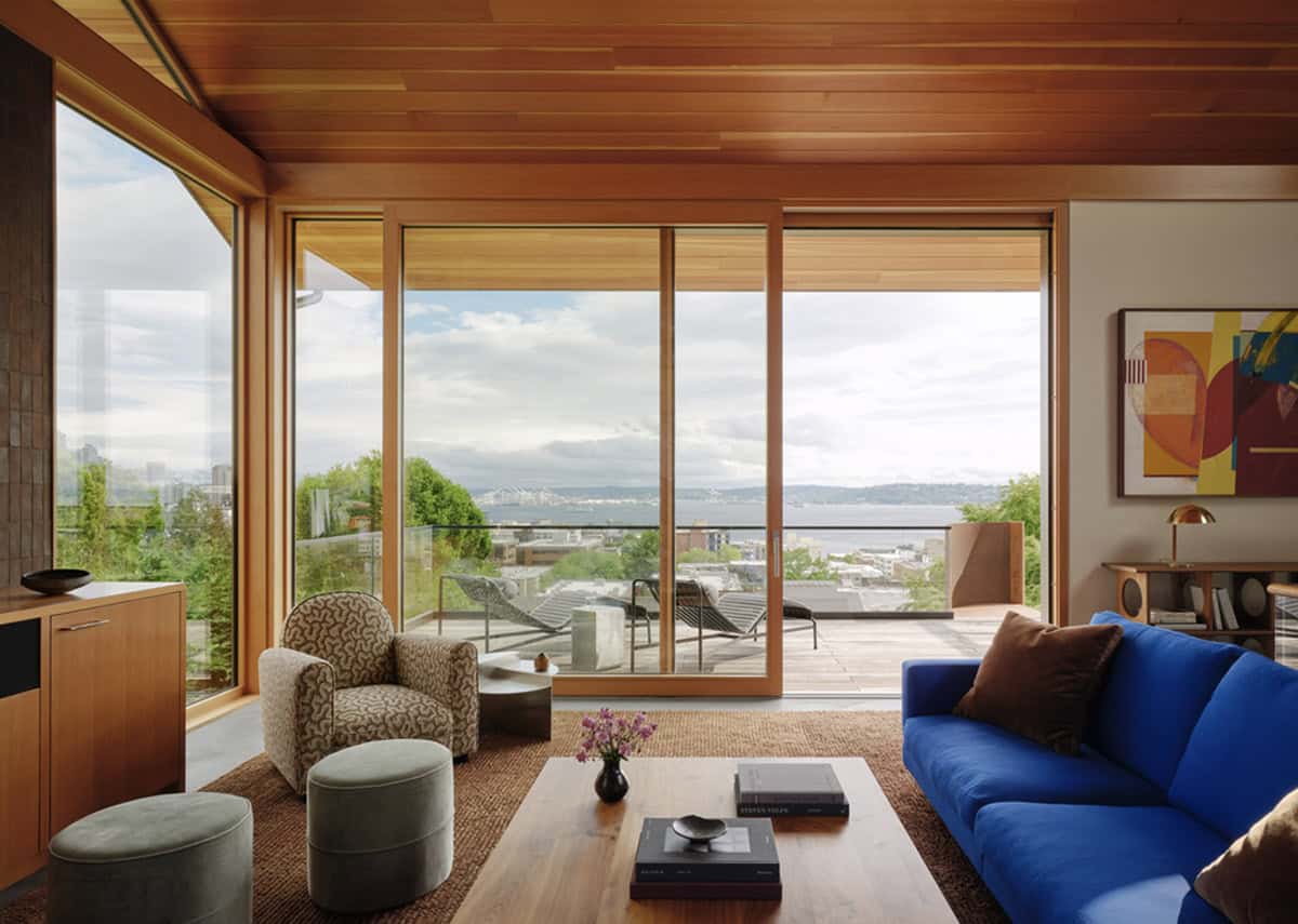 Wood-lined living room with sliding doors opening to bay views