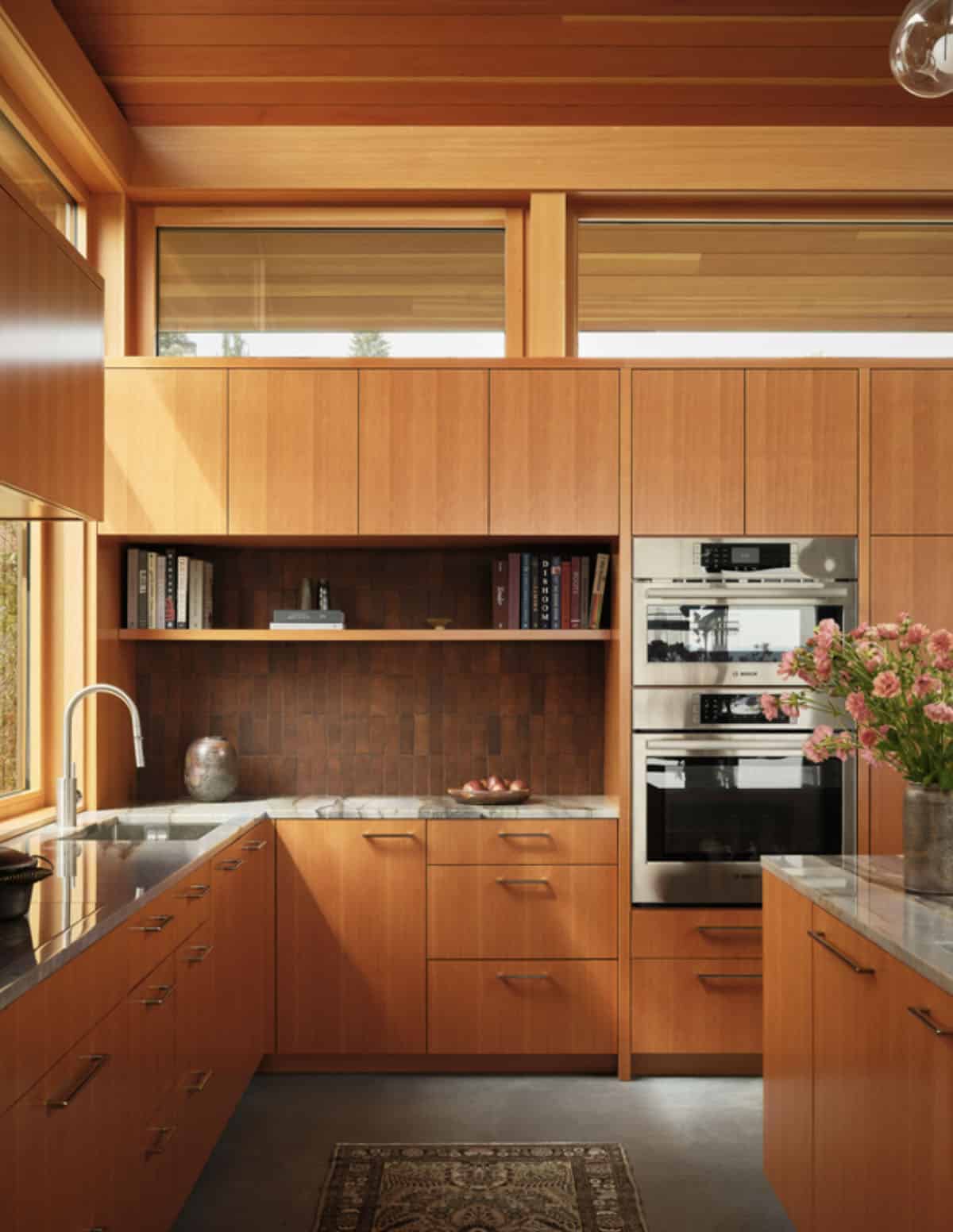 Wood cabinetry kitchen with tiled backsplash and built-in bookshelf