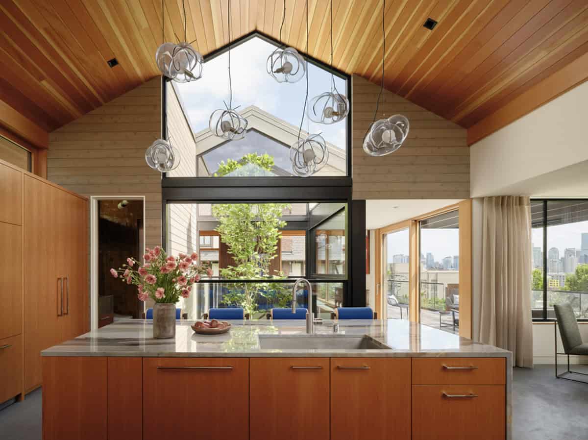Kitchen island framed by gabled atrium window and skyline view
