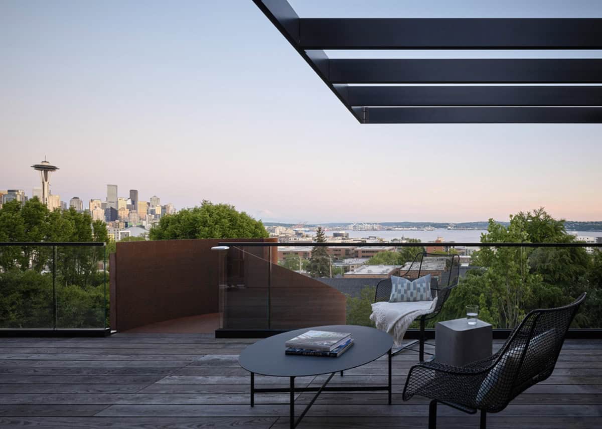 Rooftop terrace at dusk with pergola and downtown Seattle skyline