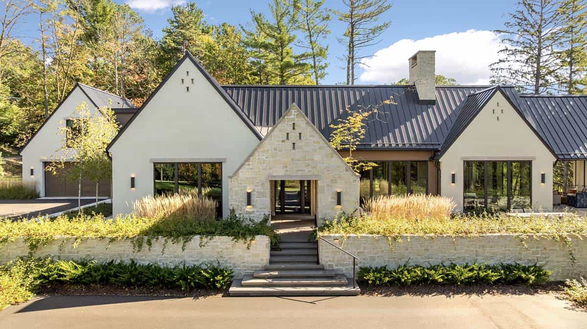 Stone and stucco exterior with dark metal roof and courtyard wall