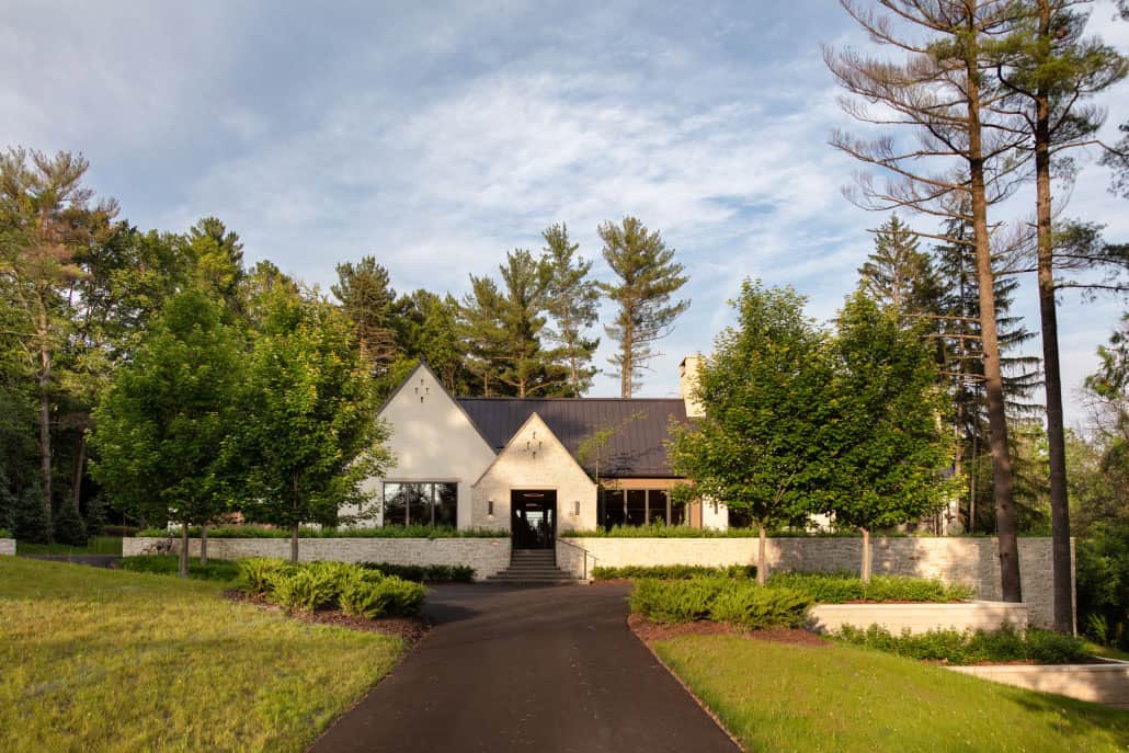 Distant dusk view of home framed by mature pine trees