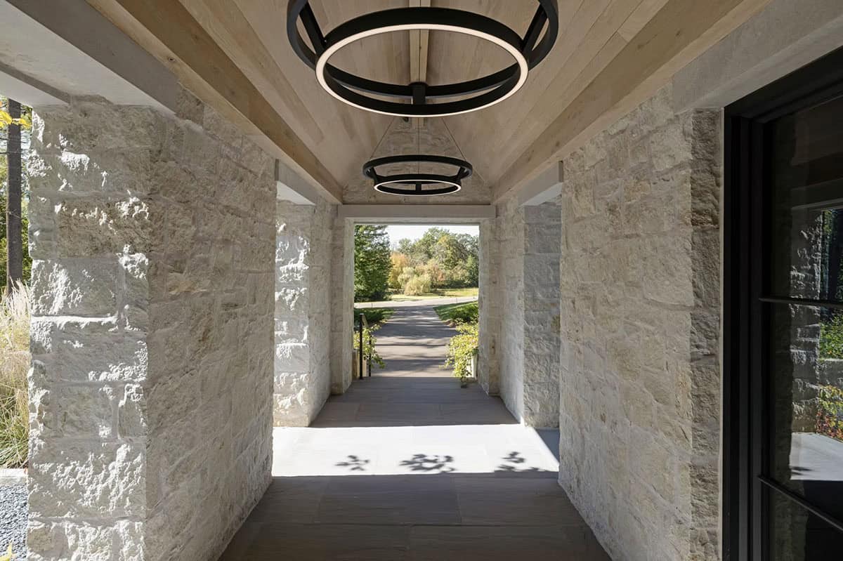 Covered stone breezeway with wood ceiling and ring pendant lights