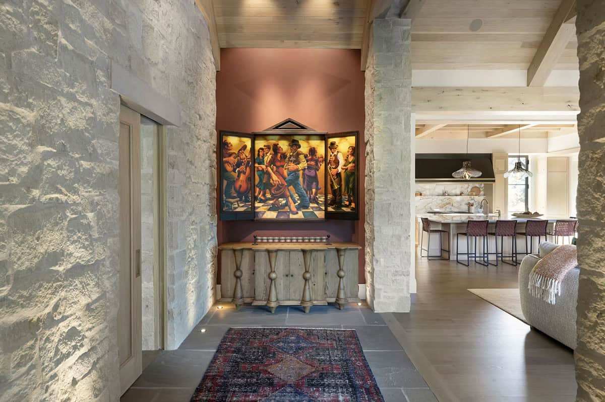 Stone entry hallway with colorful folk art triptych and console