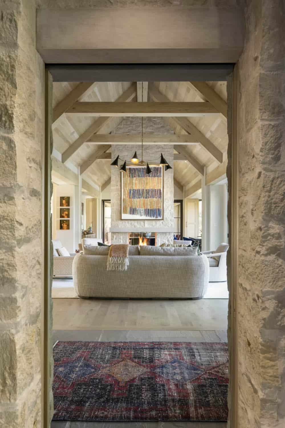 Doorway view into vaulted living room with stone fireplace column