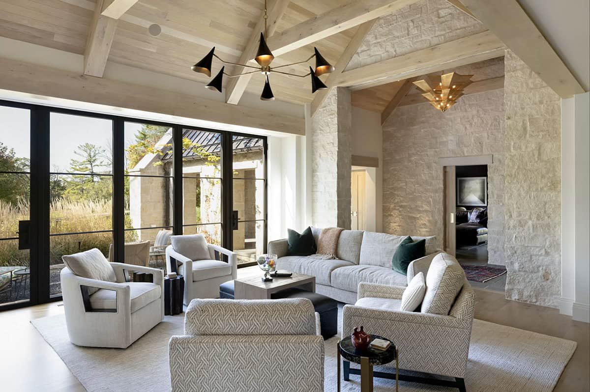 Living room with glass doors opening to stone archway hall