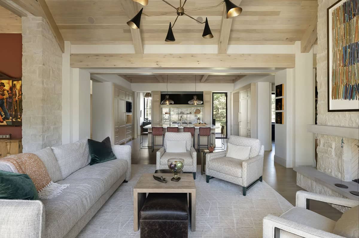 Living room facing open kitchen with wood beam ceiling