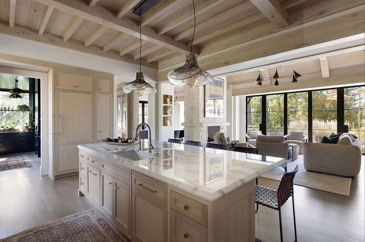 Kitchen island with marble countertop opening to living room fireplace