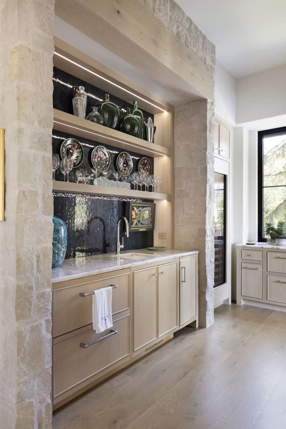 Wet bar nook with glass shelving and mosaic tile backsplash