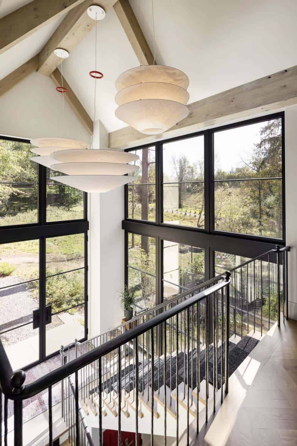 Vaulted stairwell with tiered paper pendant lights and glass wall