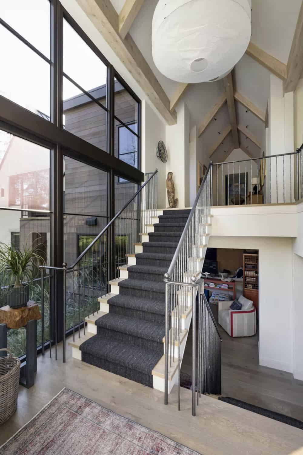 Two story stairwell with charcoal runner and iron railing