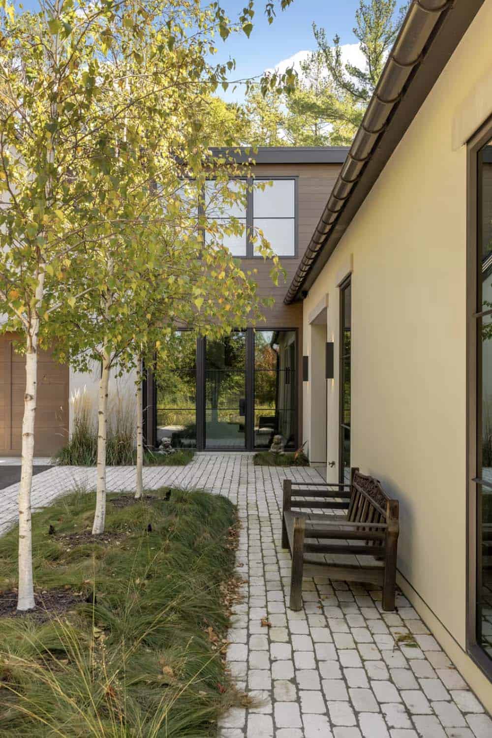 Courtyard walkway with birch trees and paver stone path