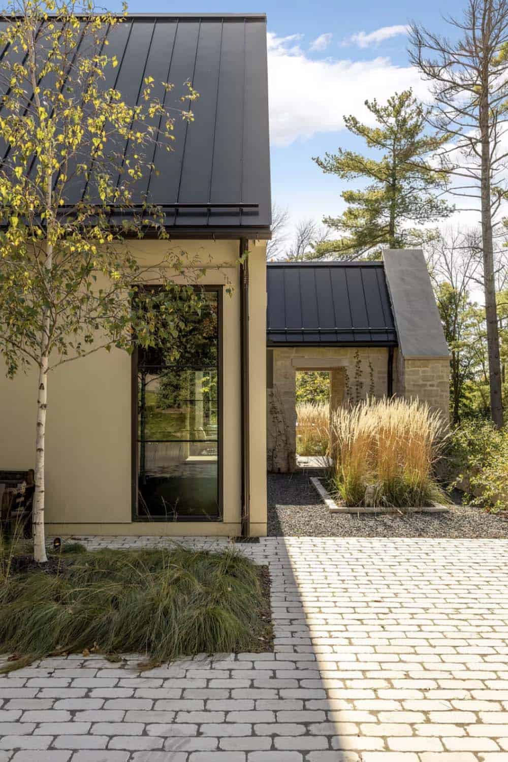 Exterior corner detail with dark standing seam roof and stone chimney
