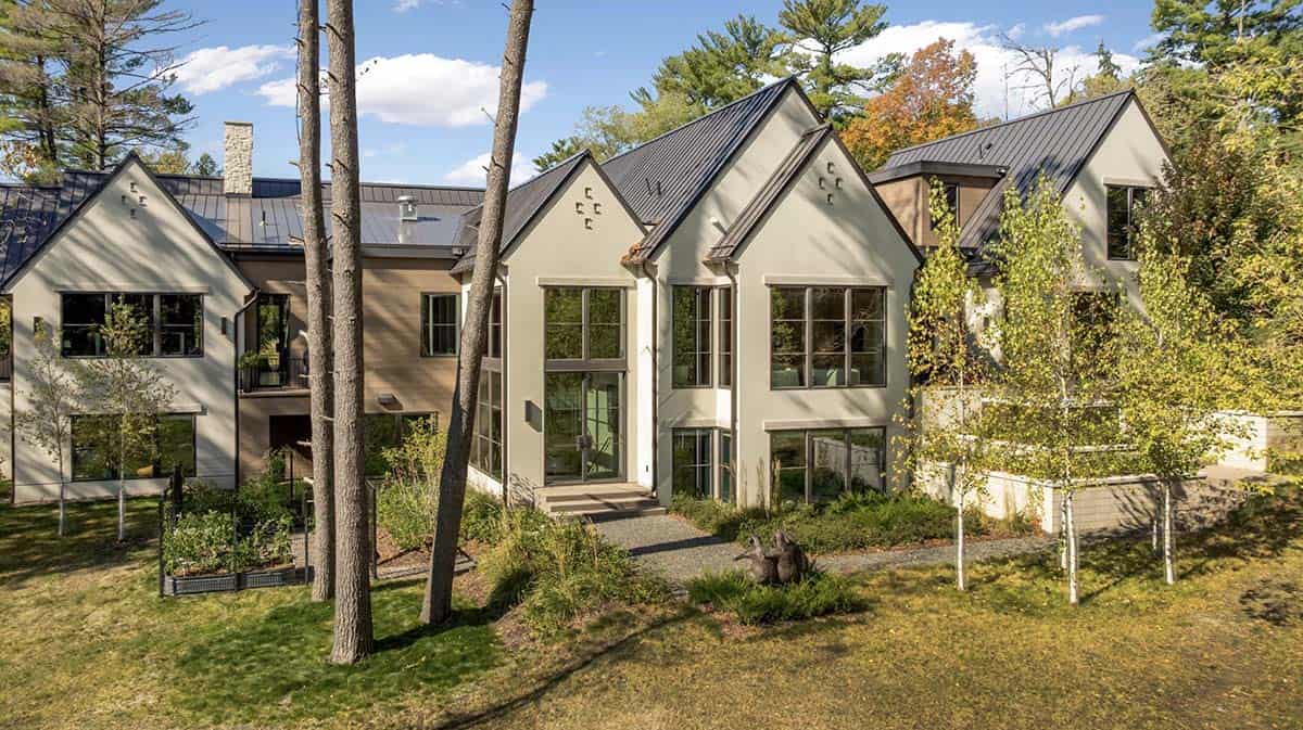 Aerial view of white stucco home surrounded by mature pines