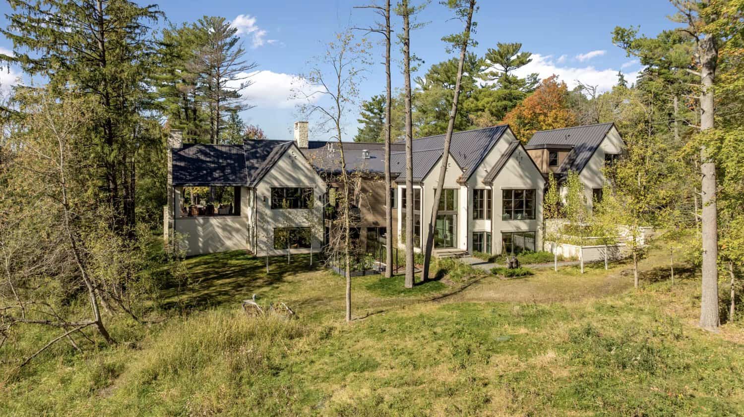 Wide aerial view of home nestled among trees and lawn