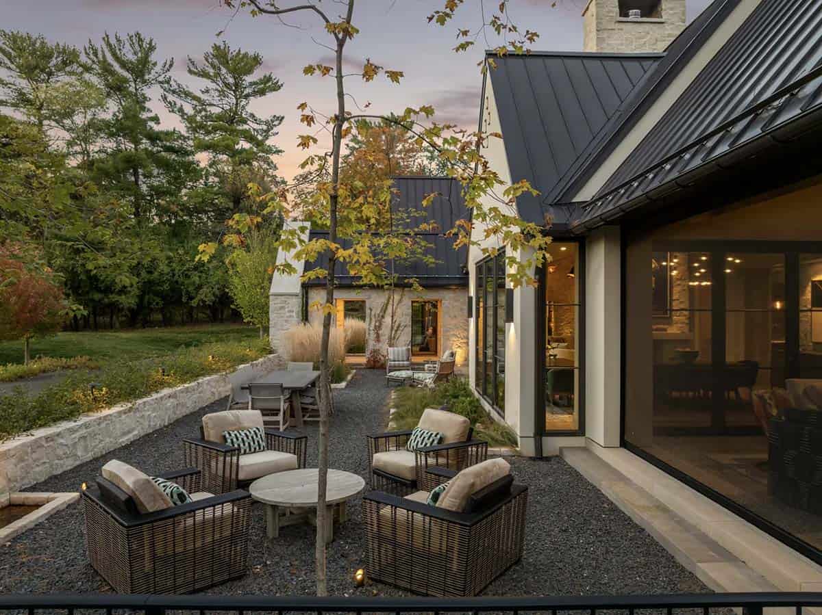 Dusk view of gravel courtyard with woven lounge seating