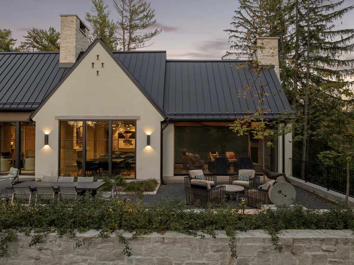 Dusk patio view with stone gable and lit interior windows