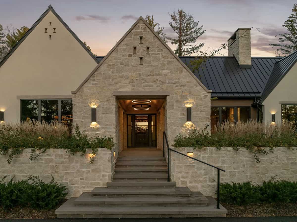 Dusk view of stone entry with glowing ring pendant light