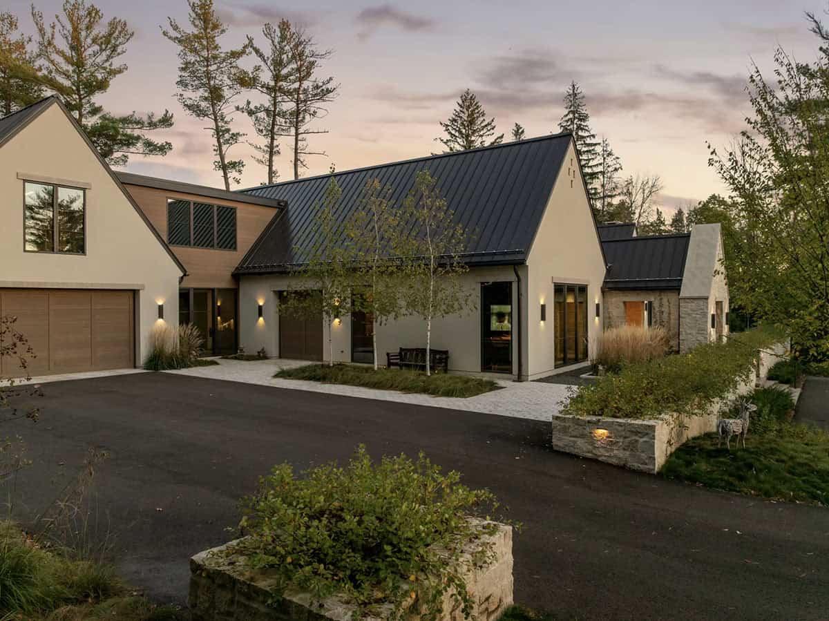 Dusk view of driveway facade with birch trees and garage