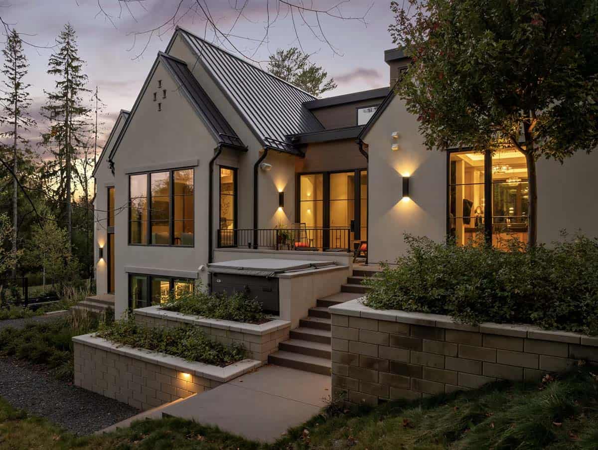 Dusk exterior with illuminated windows and stacked stone chimney