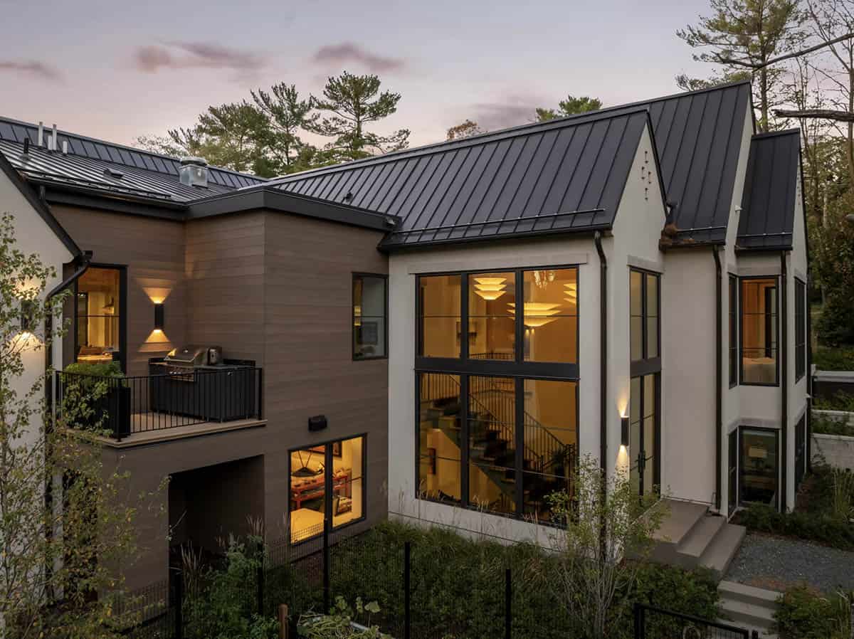 Dusk view of wood and stucco addition with balcony grill