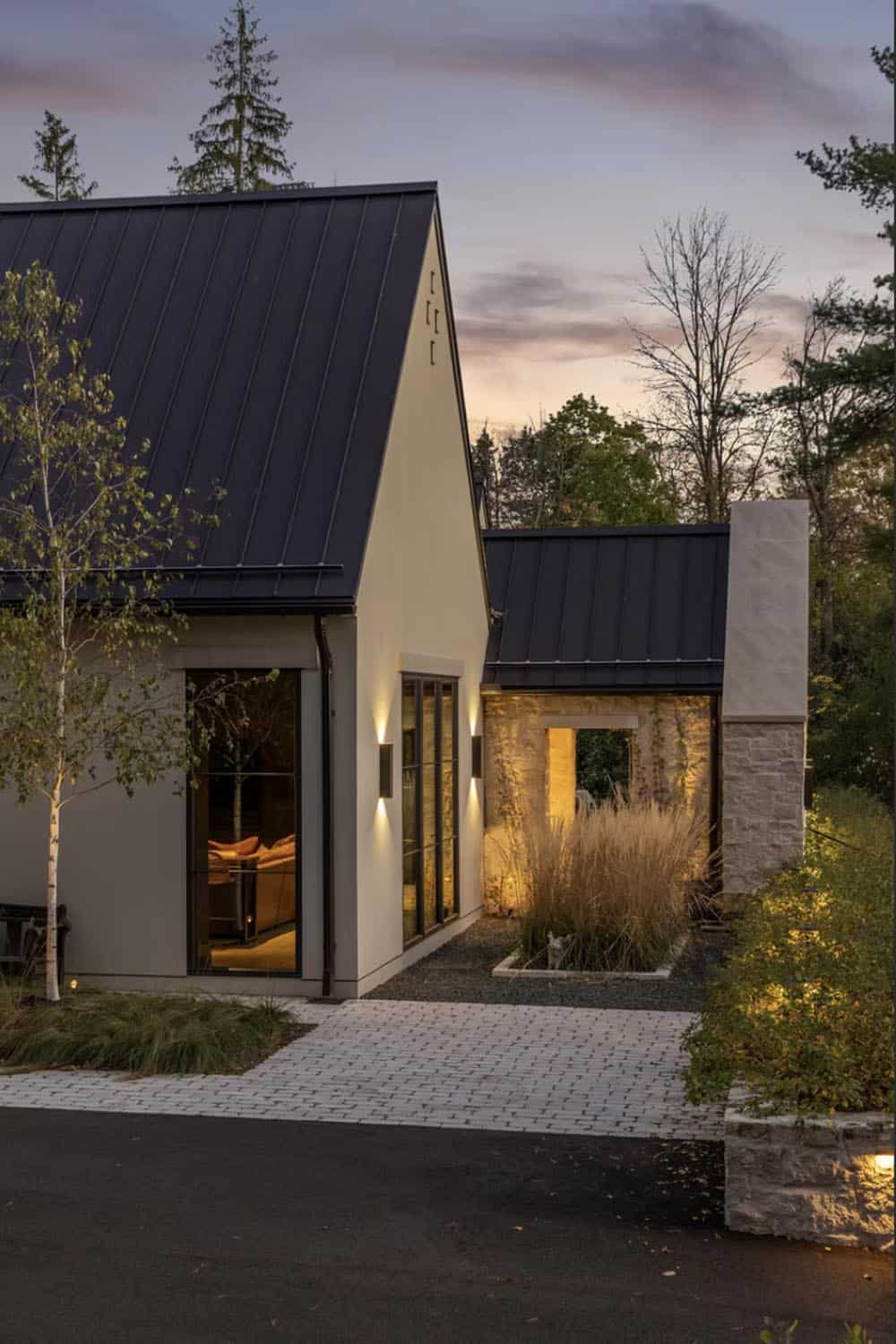 Dusk view of stone breezeway with paver walkway