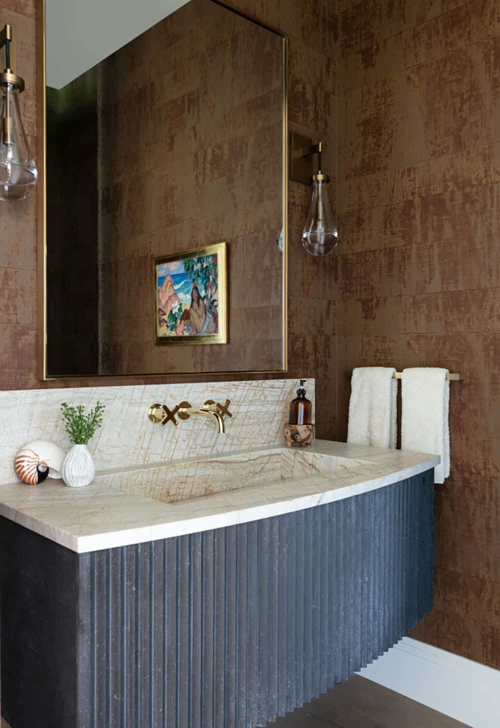 Powder room with textured wallpaper and fluted stone vanity