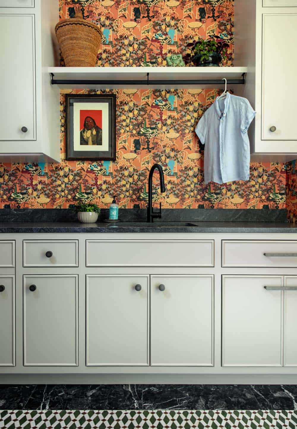 Mudroom sink with patterned wallpaper and hanging linen shirt